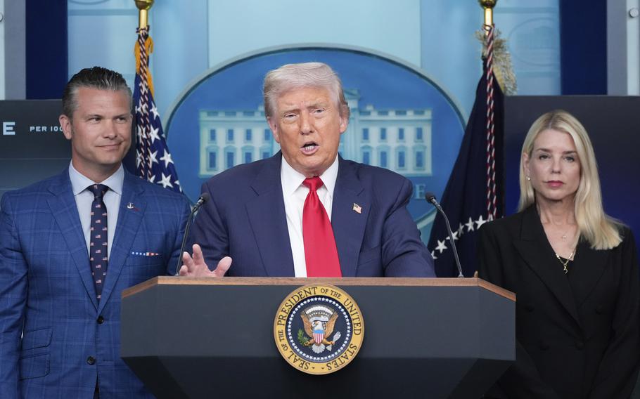 Trump speaks at a microphone, with Hegseth and Bondi flanking him.