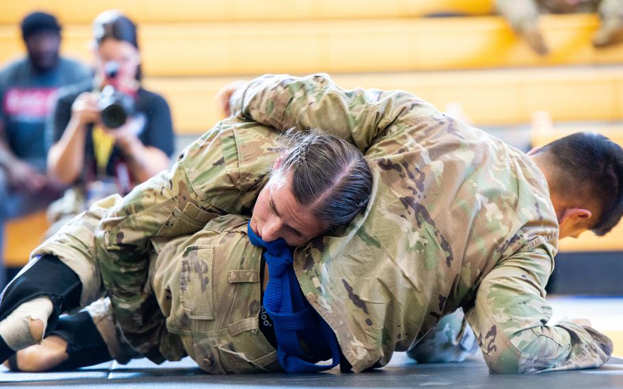 Army Capt. Rebecca Jones and 1st Lt. Dondeigo Florencio grapple during a Lacerda Cup All-Army Combatives Championship bout at Fort Benning, Ga., on Tuesday, April 11, 2023. 
