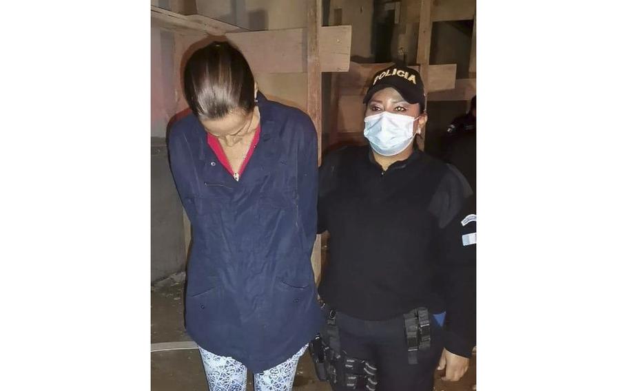 A police officer in Guatemala escorts U.S. citizen Stephanie Allison Jolluck who has been accused of trying to smuggle Mayan relics out of the country.