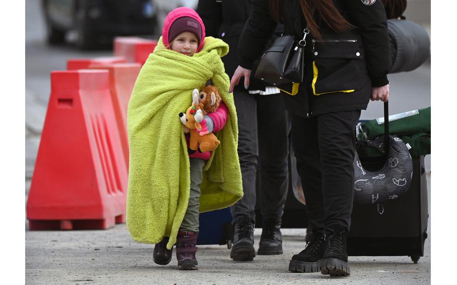 A girl hugs her stuffed animals as she crosses the border from Ukraine into Poland with her mother, March 2, 2022, at the Medyka crossing.
