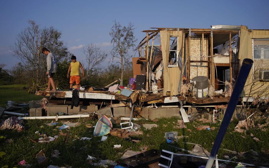 Aiden Locobon, left, and Rogelio Paredes look through the remnants of their family's home destroyed by Hurricane Ida in Dulac, La., Sept. 4, 2021. Louisiana students, who were back in class after a year and a half of COVID-19 disruptions kept many of them at home, are now missing school again after Hurricane Ida. A quarter-million public school students statewide have no school to report to, though top educators are promising a return is, at most, weeks away, not months.