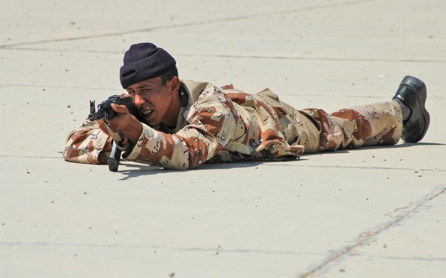 An Iraqi soldier simulates giving cover while another group of soldiers advances during a drill at Camp Independence. The U.S. soldiers use the camp to train Iraqi soldiers, who live there during weekdays but go home on the weekends. Most of the Iraqis use cabs or buses to get home, usually a two to three hour ride, the U.S. soldiers said.