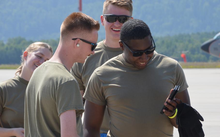 Airman 1st Class Ryan Joy, second from left, and his Expendables teammates A1C Jackson Foster, center, and Senior Airman Jordan Taft, right, watch a video of Joy driving a Tunner 60K aircraft cargo loader in the 721st Aerial Port Squadron Multi-Capability Airmen Rodeo at Ramstein Air Base, July 23, 2021.