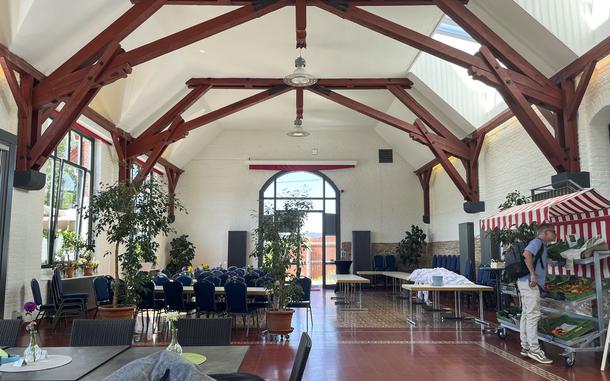 Interior of a restaurant or café with distinctive red timber-framed ceiling beams creating an arched structure.
