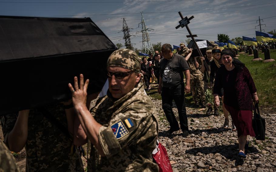 Soldiers carry caskets of their fallen comrades to their gravesites. 