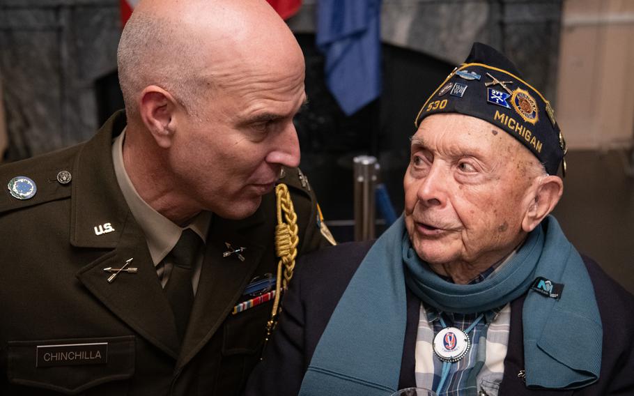 Col. Gabriel Chinchilla, left, leans in to speak to WWII veteran Ceo Bauer.