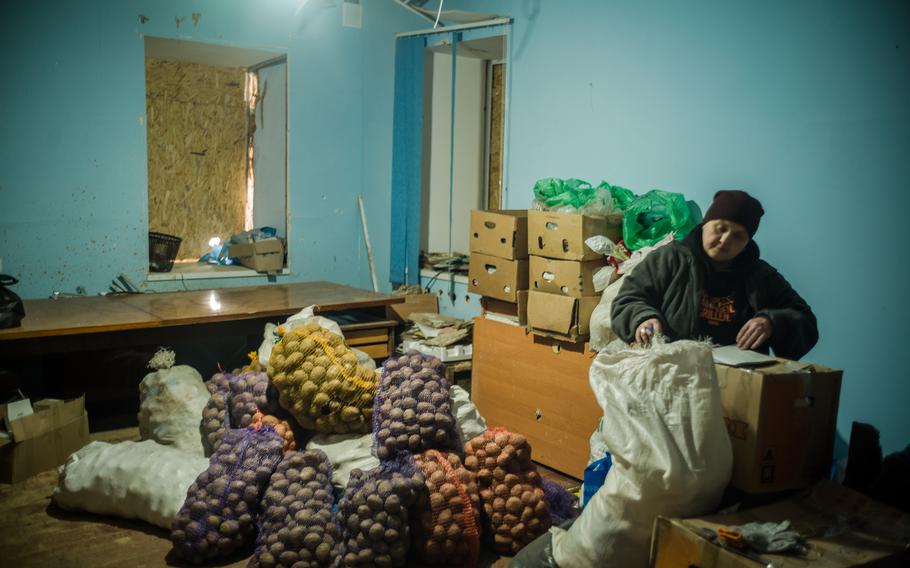 A worker at a community center distributes humanitarian aid in Oleksandrivka.