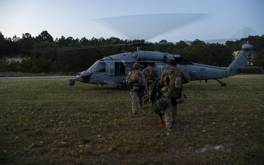 Navy SEALs load onto an MH-60S Sea Hawk helicopter from during training in June 2020 on Joint Expeditionary Base Little Creek-Fort Story, Va. Electronics Technician 1st Class Ryan DeKorte died Monday from injuries received late last week in a helicopter landing incident during an exercise at Joint Expeditionary Base Little Creek-Fort Story in Virginia.