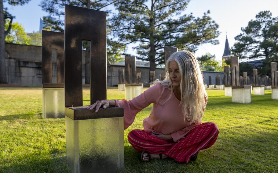 Aren Almon poses for a portrait next to the memorial chair for her daughter, Baylee Almon, at the Oklahoma City National Memorial.
