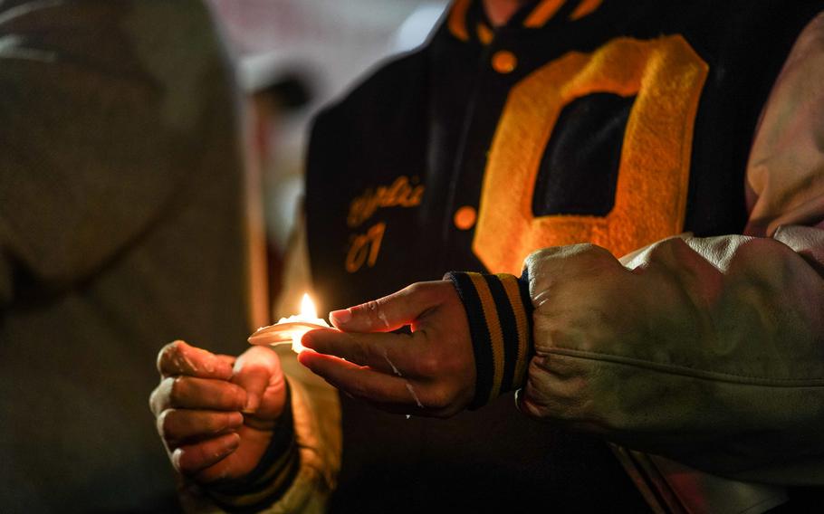 People gather during a vigil in downtown Oxford, Mich., on Dec. 3, 2021, for the Oxford community after an active shooter situation at Oxford High School left four students dead and multiple others with injuries.