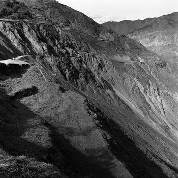 A thin road snakes through a mountainous area.