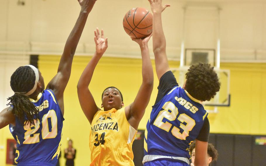 Vicenza's Jason Taylor tries to score against Sigonella's Deshawn Wallace, left, and Drake Dawson in the Jaguars' 55-28 win on Friday, Jan. 6, 2023.