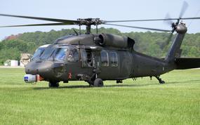 A helicopter idles in a field.