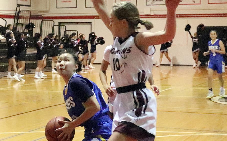 Christian Academy Japan's Sora Inoue tries to shoot against Zama's Olivia Parish during Monday's Kanto Plain girls basketball game. The Trojans won 34-24.