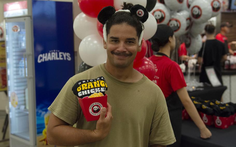 Senior Airman Christopher Hiraldo, of the 635th Materiel Maintenance Squadron at Holloman Air Force Base, N.M., poses with Panda Express merchandise during the restaurant's grand-opening at Osan Air Base, South Korea, Aug. 20, 2025. 