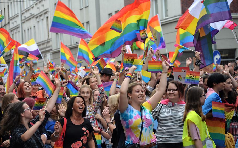 People wave rainbow flags.