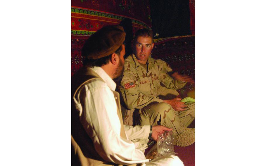 First Lt. Justin Freeman talks to mayor Abdul Mobeen as they drink tea together in the mayor’s room at the government building in Zarwuk, Afghanistan.