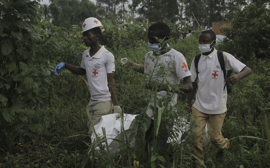 Red Cross volunteers carry the body of a civilian, who was killed in the Democratic Republic of Congo North Kivu province village of Mukondi, March 9, 2023. 