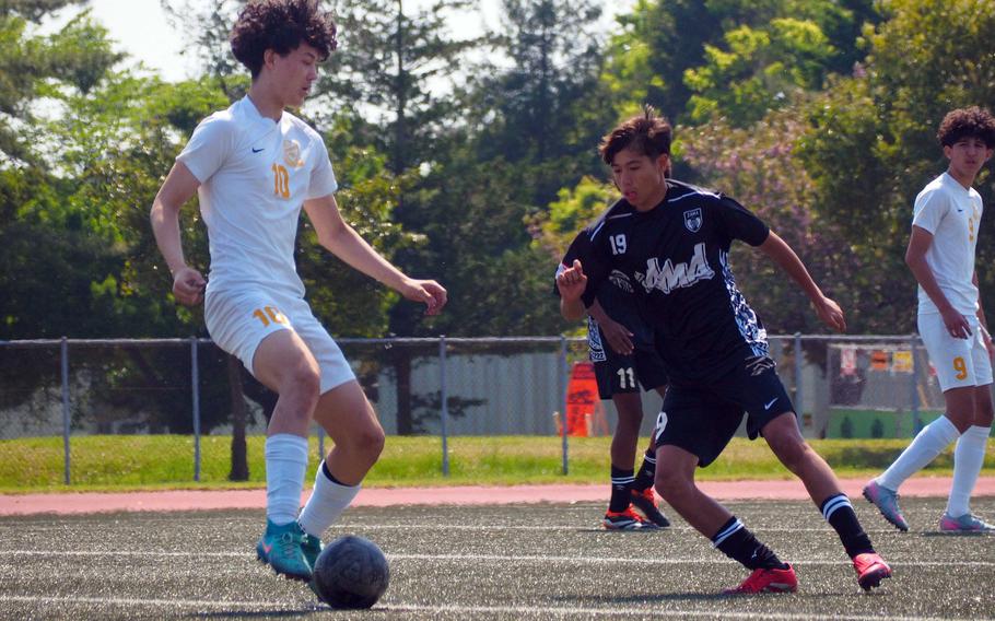 Yokota's Luke Harbert controls the ball against Zama's Conner McCale.