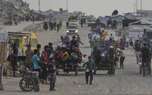 Displaced Palestinians travel on carts and vehicles through a makeshift camp along the beach in Gaza City, Sunday, Aug. 10, 2025. (AP Photo/Jehad Alshrafi)