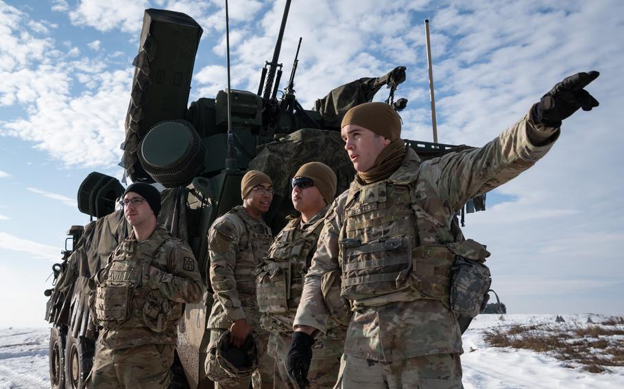 From right, Sgt. Theodore Buckley, Pvt. Ramses Ayala, Pfc. Joshua Singleton and Pfc. Ethan Calender convene outside an M-SHORAD vehicle during an exercise at Lest Training Area, Slovakia, Dec. 20, 2023. 