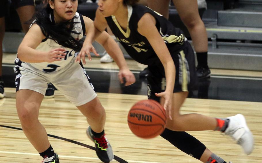 Humphreys Black’s Clarissa Parnham dribbles against Osan’s Margaux Edquid during Saturday’s DODEA-Korea girls basketball game, won by the Cougars 34-30.