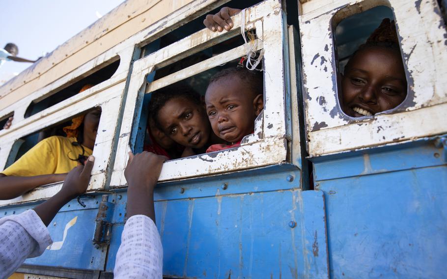 Refugees who fled the conflict in Ethiopia’s Tigray region ride a bus going to the Village 8 temporary shelter, near the Sudan-Ethiopia border, in Hamdayet, eastern Sudan on Dec. 1, 2020. 