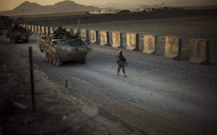 U.S. soldiers from the 5th Striker Brigades walk next to armored vehicles as they arrive at their base on the outskirts of Spin Boldak, about 63 miles southeast of Kandahar, Afghanistan, Aug. 8, 2009.