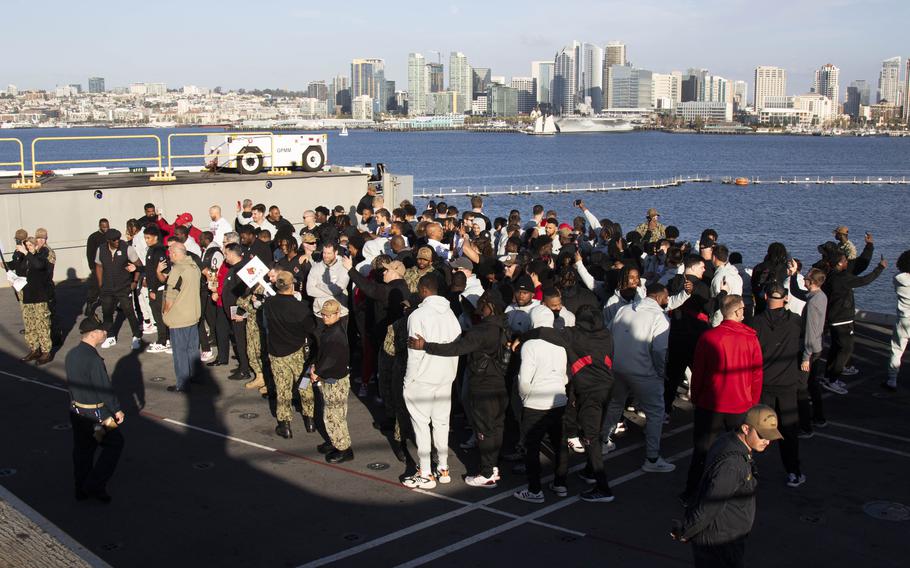 Louisville Cardinals football players pose for a photo Dec. 24, 2023, during an open ship tour aboard the Nimitz-class aircraft carrier USS Abraham Lincoln prior to the 2023 Holiday Bowl. Abraham Lincoln is currently moored pierside at Naval Air Station North Island. 