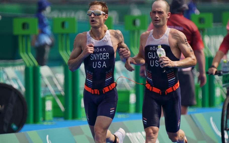 Team USA’s Bradley Snyder, left, and Greg Billington run in a Tokyo Paralympics triathlon at Odaiba Marine Park, Saturday, Aug. 28, 2021. Snyder is a Navy veteran who lost his sight from a blast in Afghanistan in 2011.