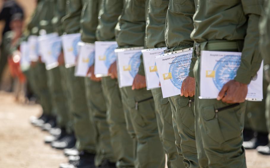 Syrian training academy members hold certificates of completion during a graduation ceremony April 3, 2023.