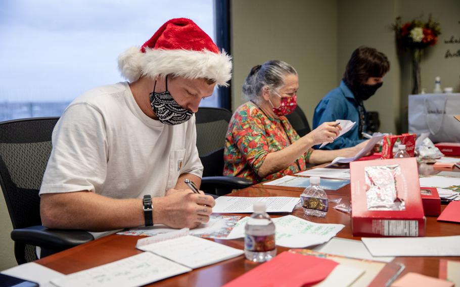 Residential program participants Devon Edwards, Linda Perez, and Gary Dellisant write responses to children's letters to Santa at San Diego Rescue Mission on Friday, Dec. 10, 2021.