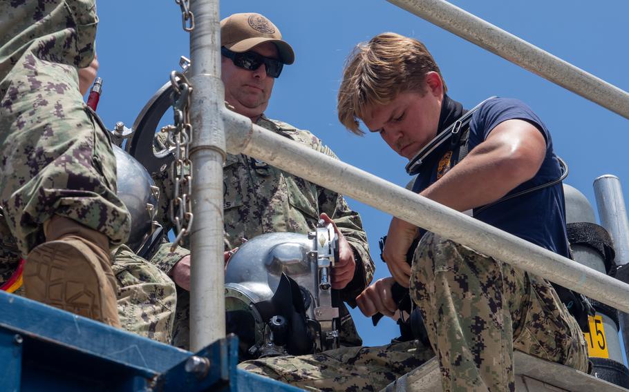A navy diver puts on diving equipment