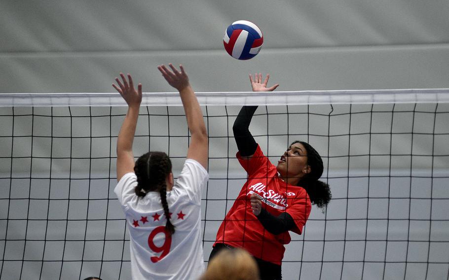 Red Team's Jasmine Jones jumps to slam the ball while White Team's Kennedy Lange of Ansbach goes up for the block during a DODEA-Europe all-star volleyball match on Nov. 4, 2023, at Ramstein High School on Ramstein Air Base, Germany.