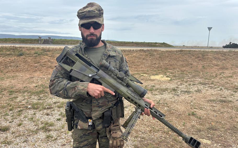 A Spanish soldier shows off a British Accuracy International bolt-action sniper rifle.