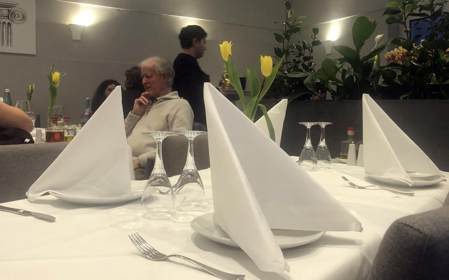 Inside the Parthenon restaurant in Frankfurt. It features white table linens and flowers on every table.