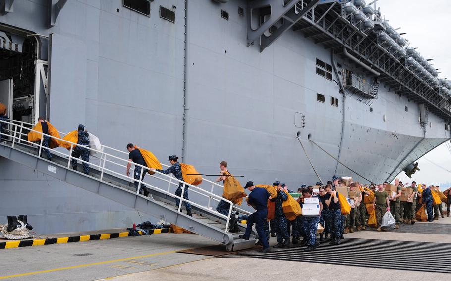 Sailors and Marines move mail onto the amphibious assault ship USS Makin Island during a stop in Singapore, Dec. 12, 2011. 
