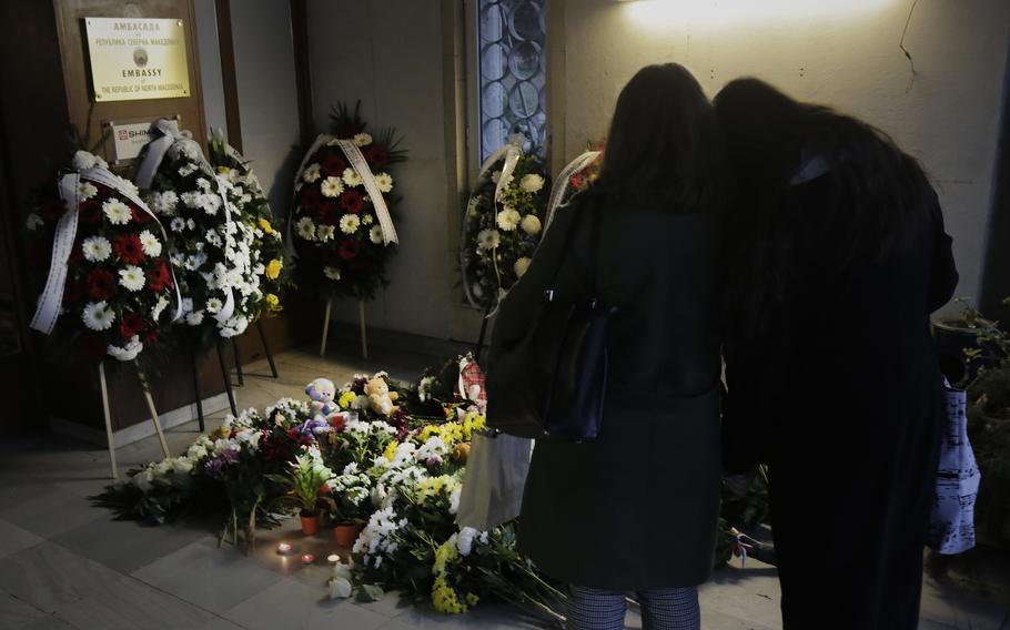 People light candles and lay flowers at the North Macedonian embassy in Sofia, Wednesday, Nov. 24, 2021, as they pay their respects to the victims of a bus crash. Bulgaria and North Macedonia began periods of national mourning on Wednesday, a day after a bus traveling through Bulgaria carrying tourists to neighboring North Macedonia crashed and caught fire, killing 45 people.
