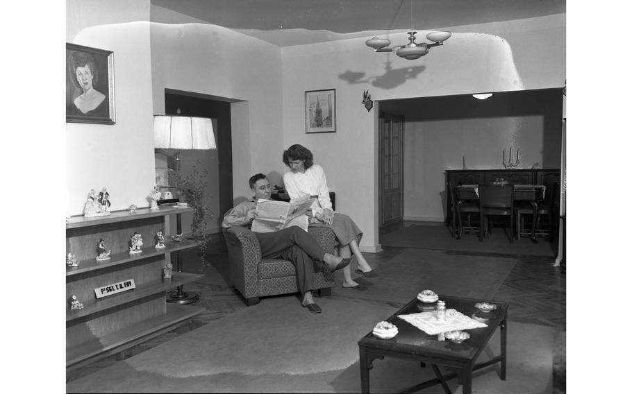 1st Sgt. Thomas H. Fay, of H Co., 18th Inf., 1st Div., reads his newspaper and his wife Betty Jo relaxes in the living room of their new apartment, one of the 156 newly constructed apartment units for service members and their families in Aschaffenburg.