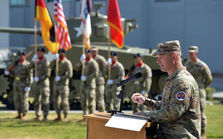 Brig. Gen. Steven Carpenter at a podium as the Army Color Guard holds flags.