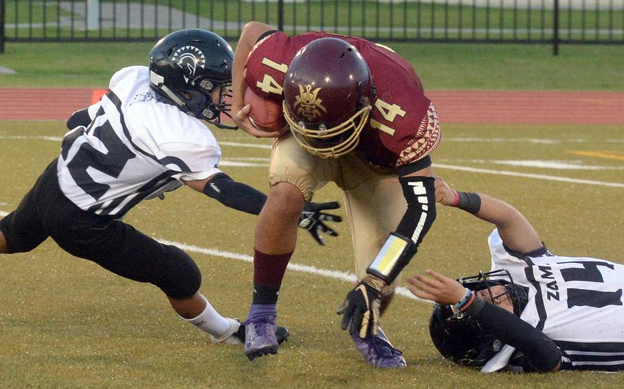 Matthew C. Perry quarterback Roy Clayton eludes Zama  defenders Hiroki Davis and Kai Kuroki en route to a 75-yard TD run.