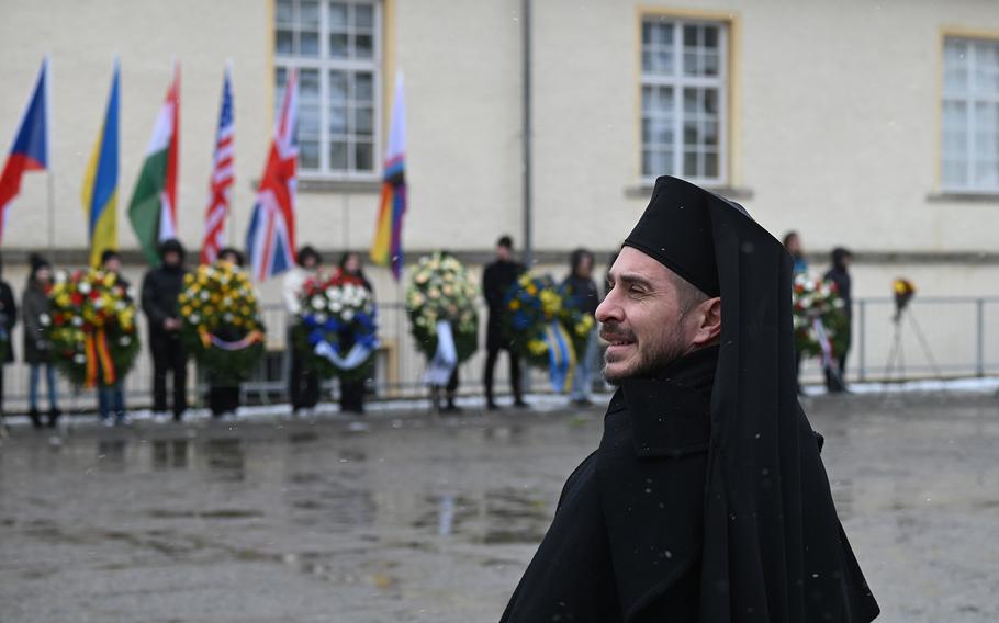 A member of the clergy heads into the elements for a service honoring the tens of thousands who died at the hands of the Nazis at the Flossenbürg concentration camp in Germany, April 21, 2024. 
