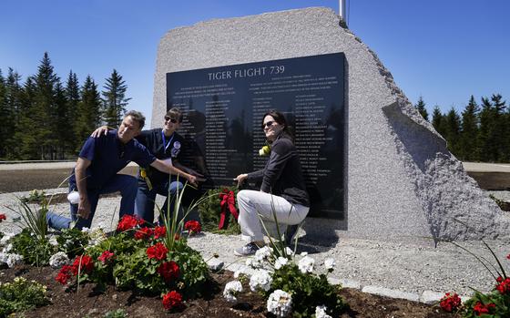 John Williams, of Peru, Ind., left, and his sisters, Maria McCauley, of Branson, Mo., center, and Susie Linale, of Omaha, Neb., pose at a monument to honor the military passengers of Flying Tiger Line Flight 739, Saturday, May 15, 2021, in Columbia Falls, Maine. Their father, SFC Albert Williams, Jr., was among those killed on the secret mission to Vietnam in 1962. (AP Photo/Robert F. Bukaty)