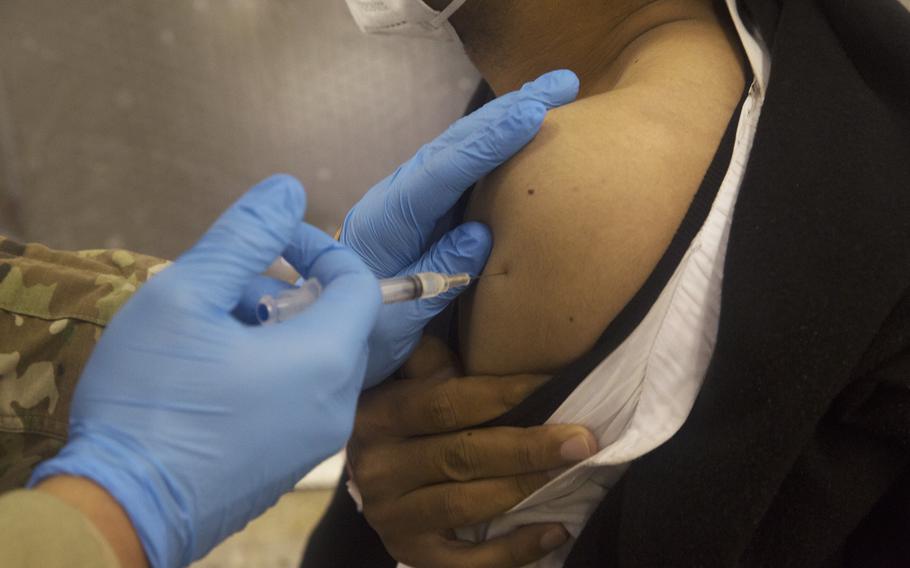 Pfc. Riley Tiedt, assigned to the 2-127th Infantry Regiment, 32nd Infantry Division, Wisconsin National Guard, administers a COVID vaccination to an Afghan evacuee during Operation Allies Welcome at Fort McCoy, Wis., Sept. 3, 2021. 