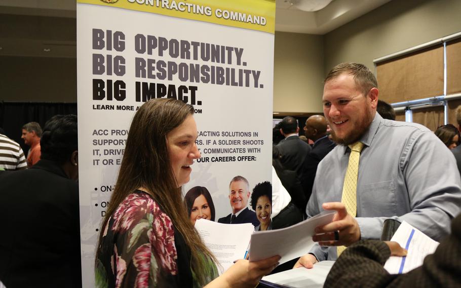 A personnel support specialist with the Army Contracting Command at Redstone Arsenal, Ala., speaks with a job candidate about opportunities during an Army job fair in 2018.