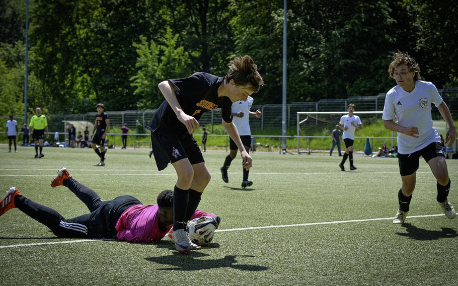 Baumholder goalie Elijah Washington slides to grab the ball from the feet of Spangdahlem’s William Crofton during the 2024 DODEA European Soccer Division III Championships in Landstuhl, Germany, on May 20, 2024.