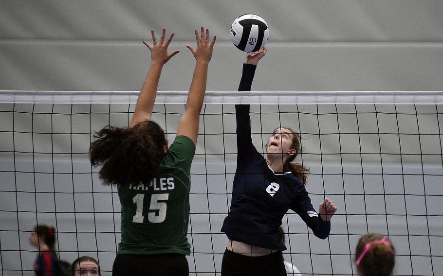Black Forest Academy's Danielle Cherry attacks while Naples' Mackinzi Dudley blocks during a Division II semifinal match at the DODEA European volleyball championships on Oct. 27, 2023, at Ramstein High School on Ramstein Air Base, Germany.