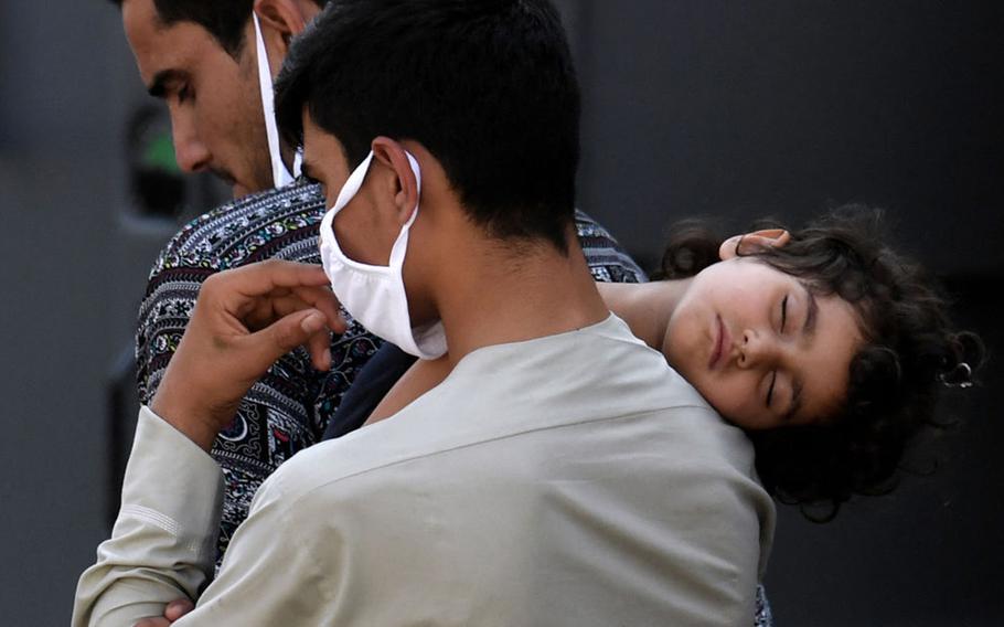 Afghan refugees arrive at a processing center in Chantilly, Va., on Aug. 23, 2021, after arriving on a flight at Dulles International Airport.