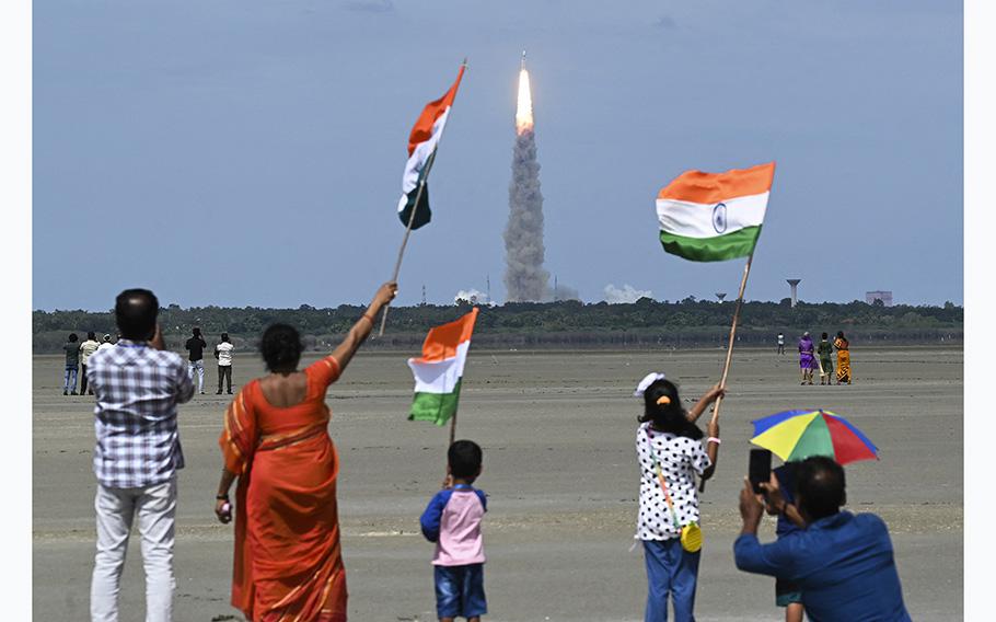 Spectators wave flags as an Indian Space Research Organisation rocket carrying the Chandrayaan-3 spacecraft lifts off from the Satish Dhawan Space Center in Sriharikota, an island off the coast of southern Andhra Pradesh state on July 14, 2023.