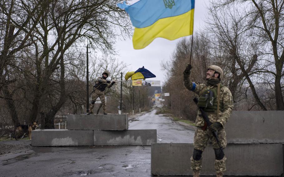 Ukrainian soldiers celebrate at a check point in Bucha, in the outskirts of Kyiv, Ukraine, April 3, 2022. 
